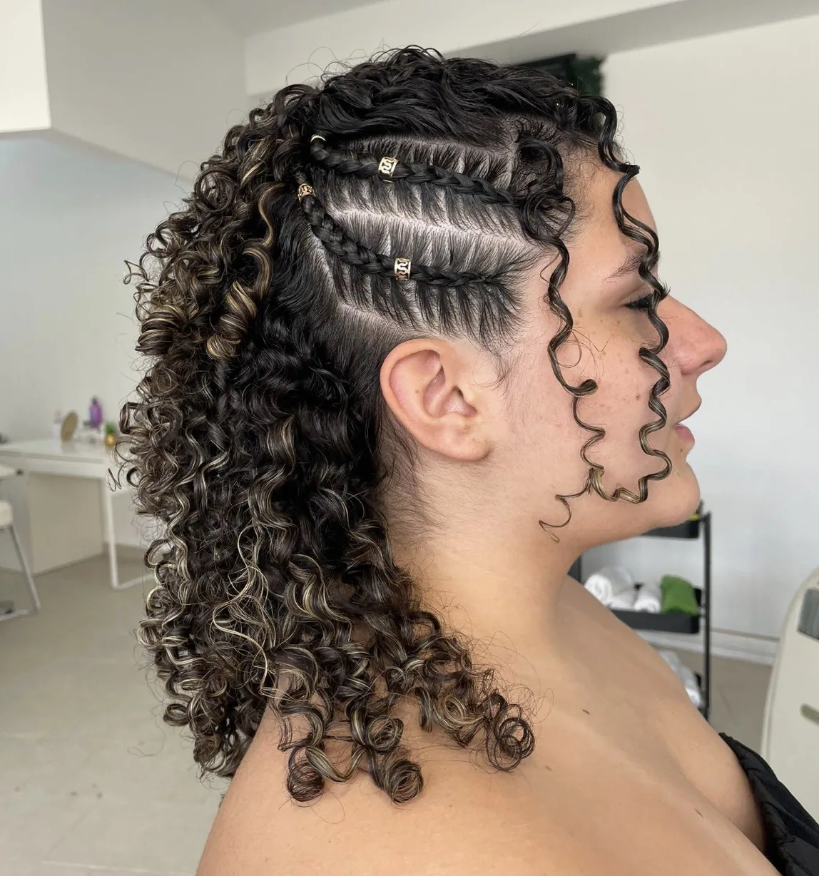 Penteado cacheado com tranças laterais e acessórios dourados